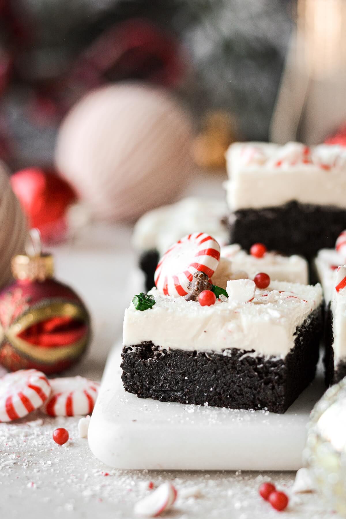 Frosted peppermint brownie on a marble board.