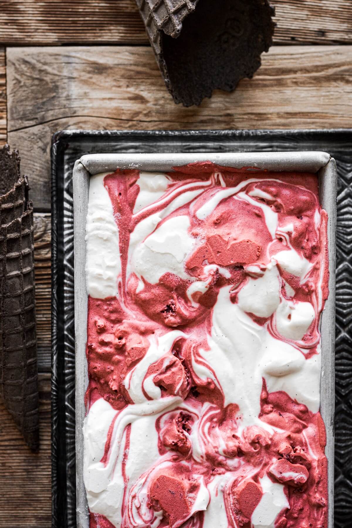 Red velvet swirl ice cream in a metal loaf pan.