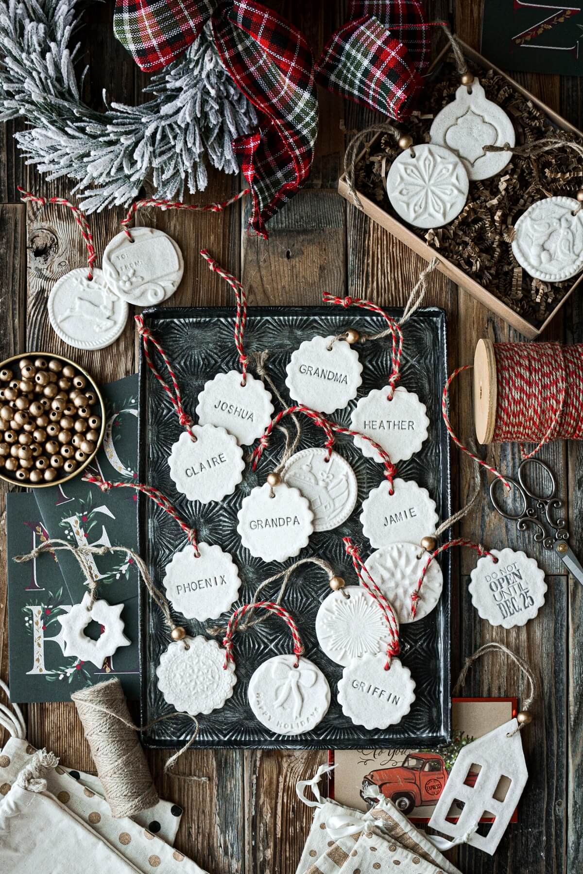 Salt dough Christmas ornaments surrounded by twine, beads and a wreath.