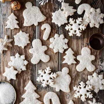 Sparkling sugar cutout almond Christmas cookies on a wooden table.