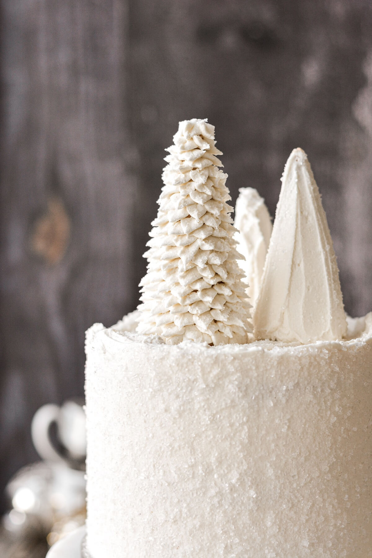 Three ice cream cones frosted like Christmas trees on a cake.