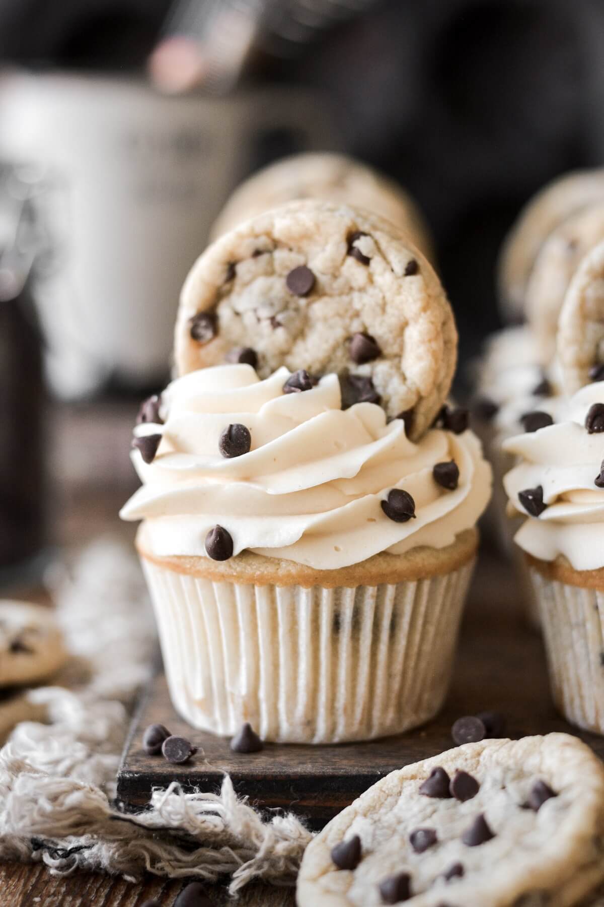 Chocolate chip cupcake with a mini chocolate chip cookie on top.