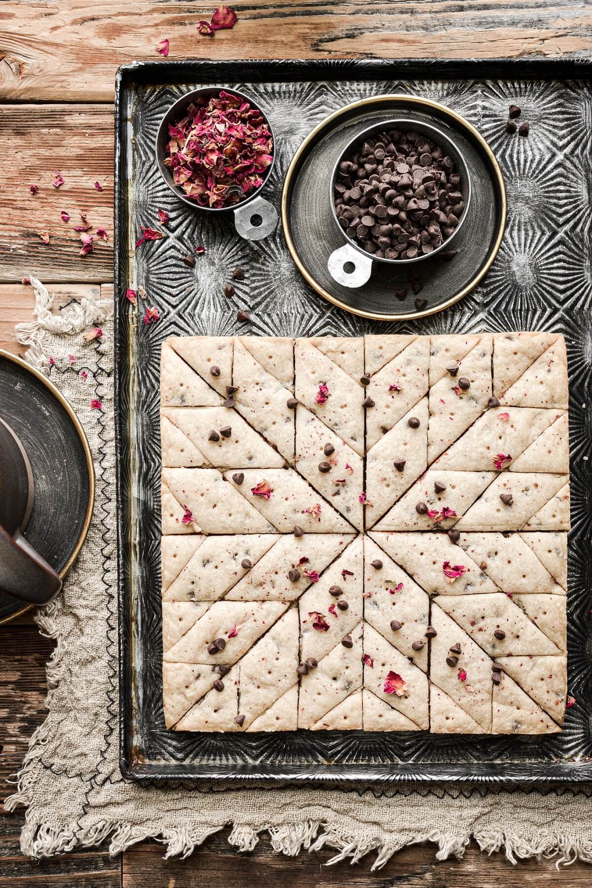 Chocolate chip shortbread decorated with chocolate chips and edible rose petals.