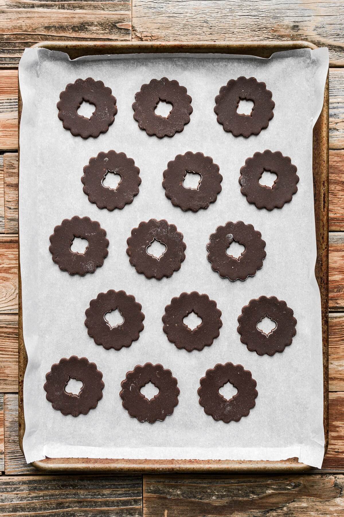 Cutout chocolate sugar cookies on a baking sheet.