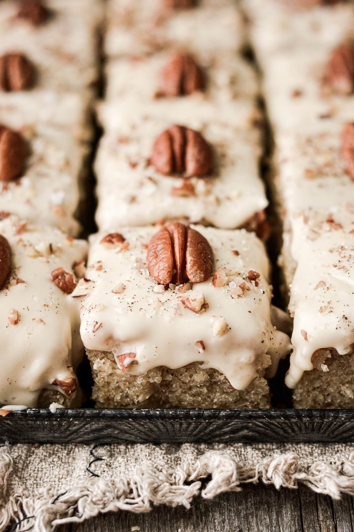 Squares of eggnog pecan cake topped with pecan halves.