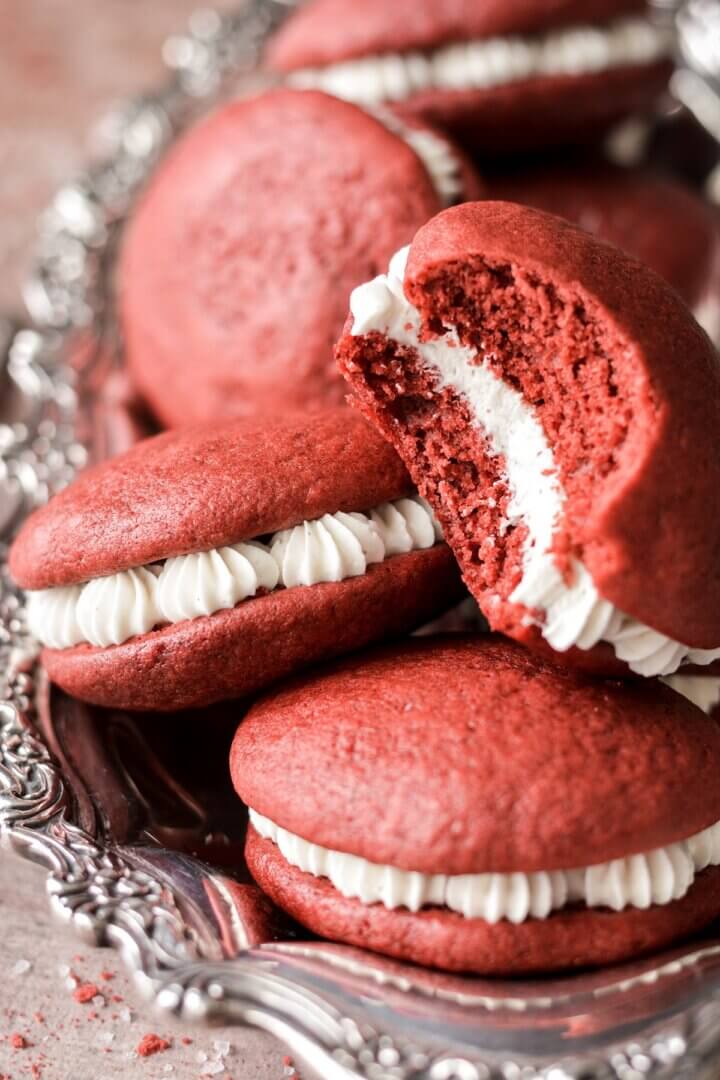 Red velvet whoopie pies, one with a bite taken.