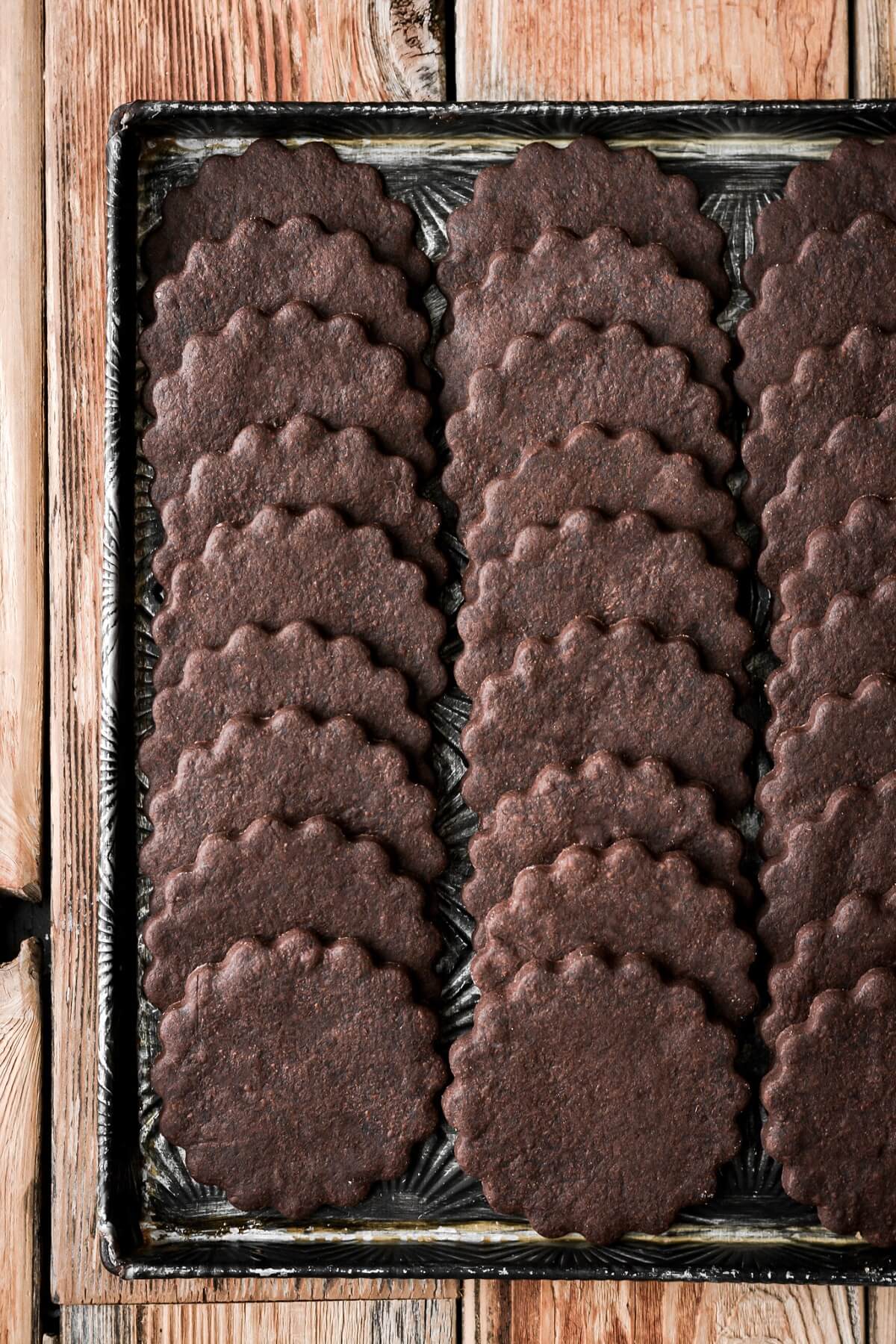 Chocolate sugar cookies with scalloped edges.