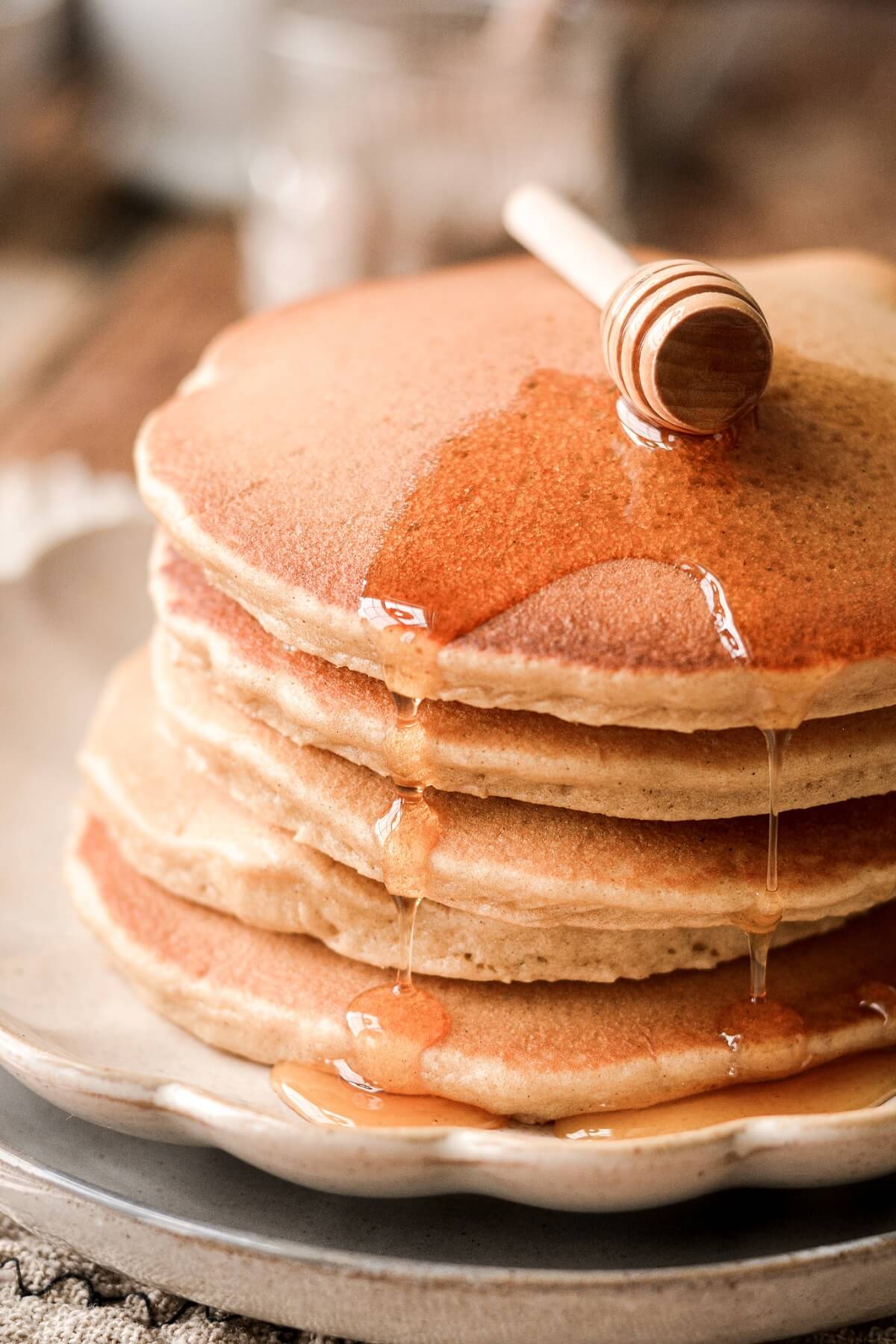 Honey dripping on top of whole wheat pancakes.
