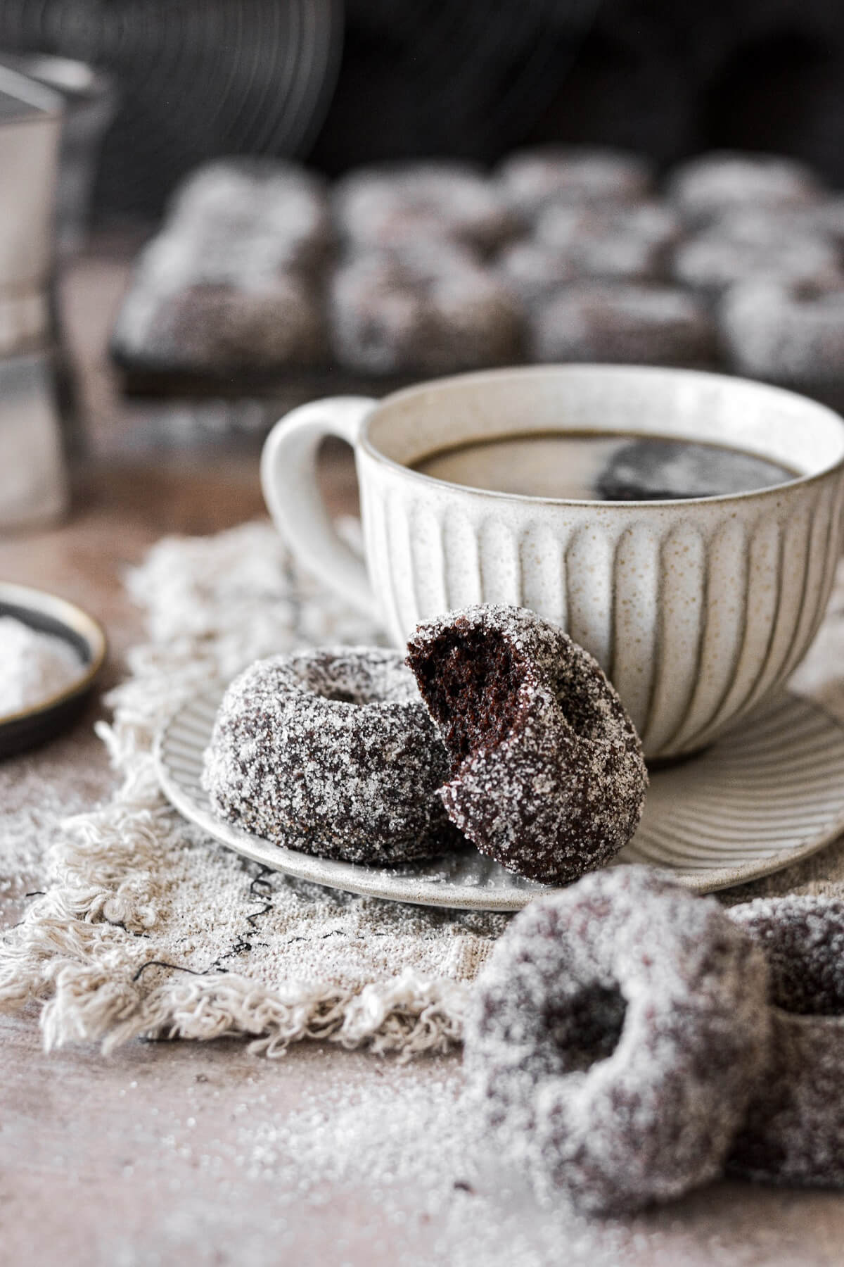Sugar coated chocolate doughnuts with a cup of coffee.
