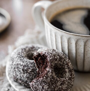 Sugar coated chocolate doughnuts with a cup of coffee.