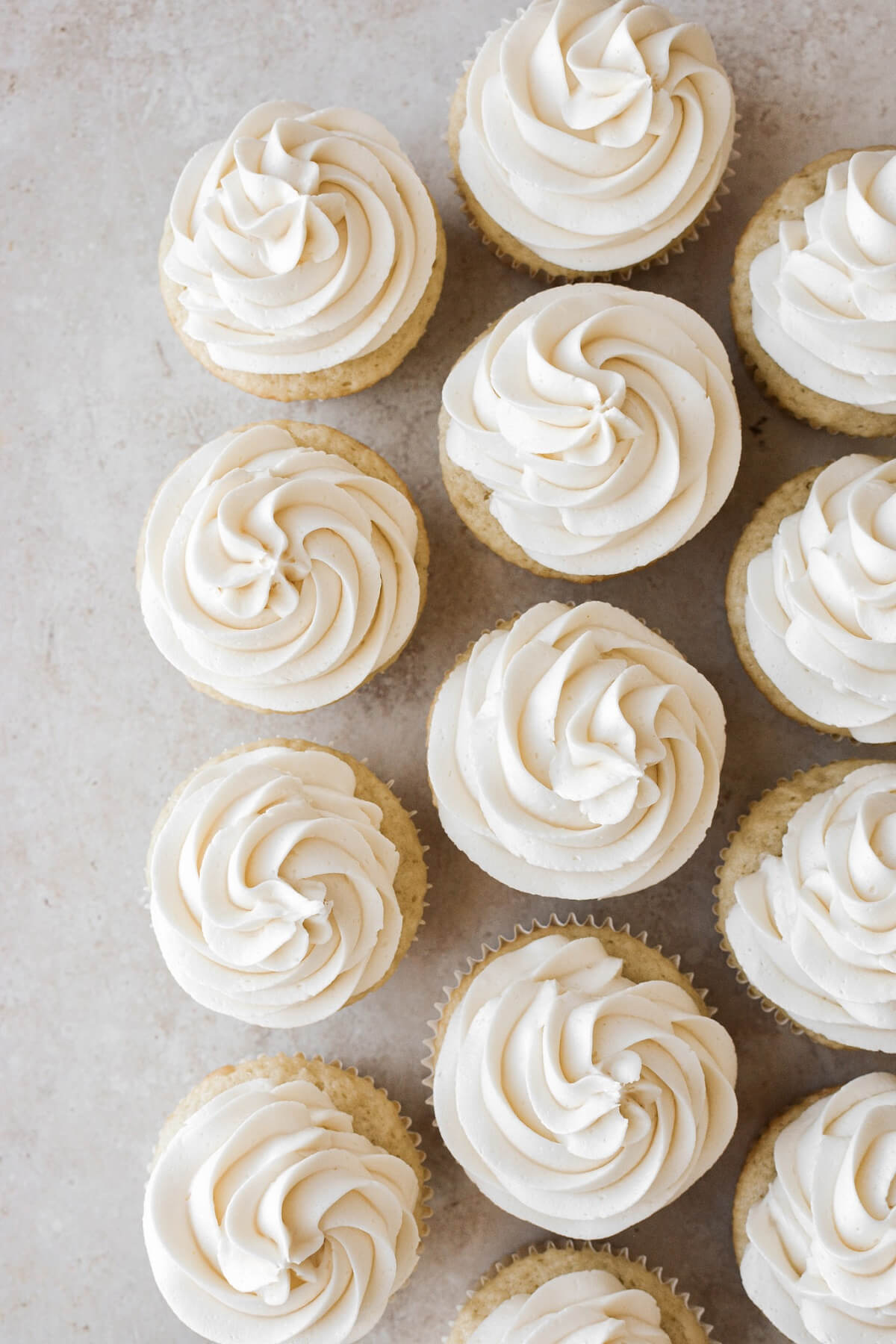 Coconut buttercream piped onto coconut cupcakes.
