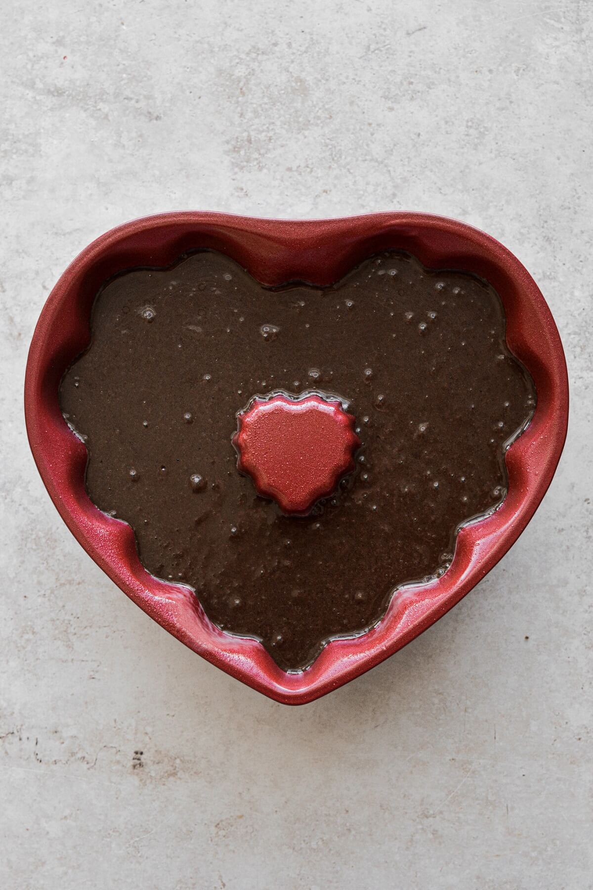 Chocolate cake batter in a heart chaped bundt pan.