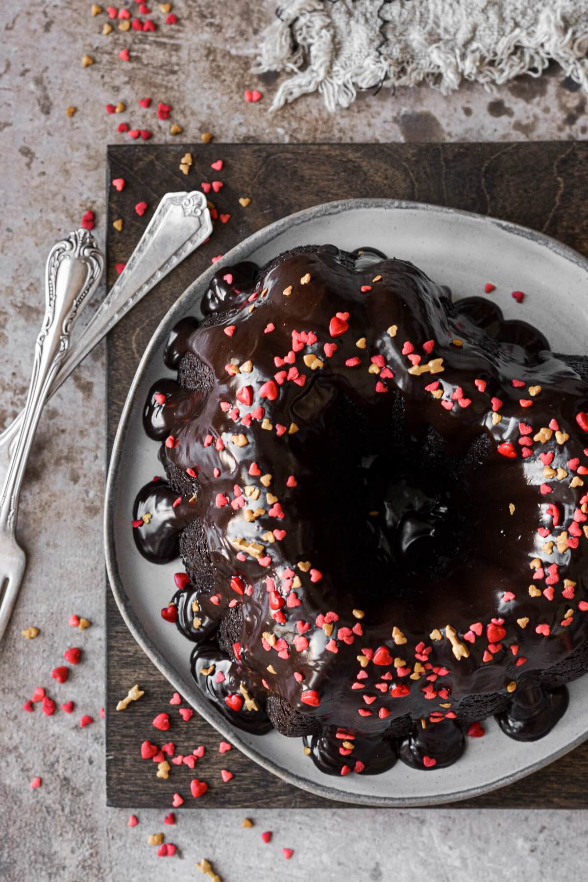 Chocolate ganache and sprinkles on a heart shaped mini chocolate bundt cake.
