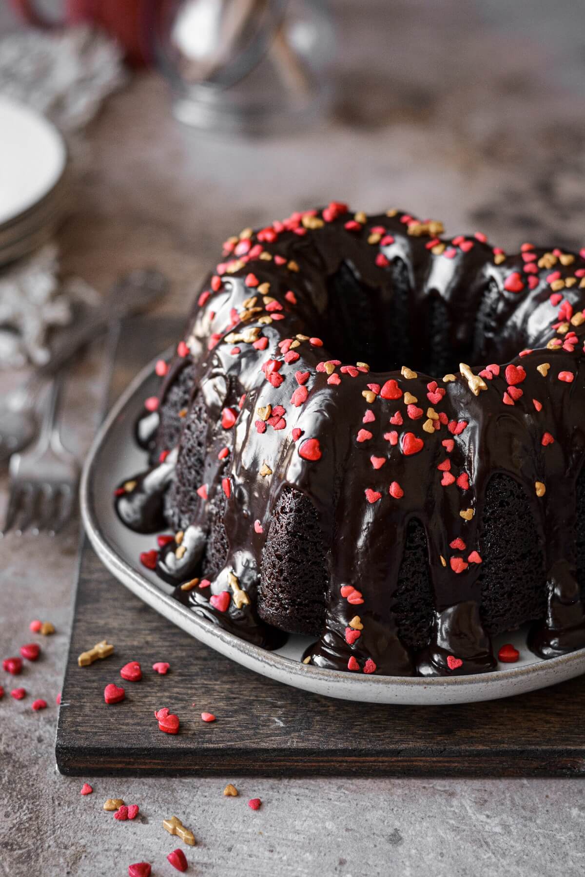 Heart sprinkles and ganache on a chocolate bundt cake.