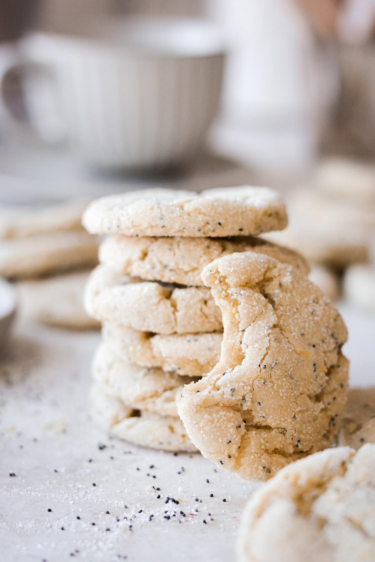 Stack of lemon poppy seed cookies, next to a cookie with a bite taken.