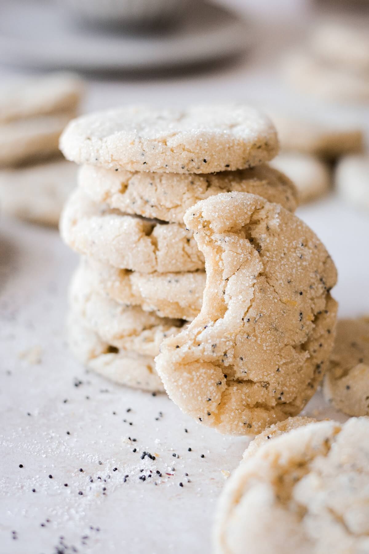 Stack of lemon poppy seed cookies, next to a cookie with a bite taken.