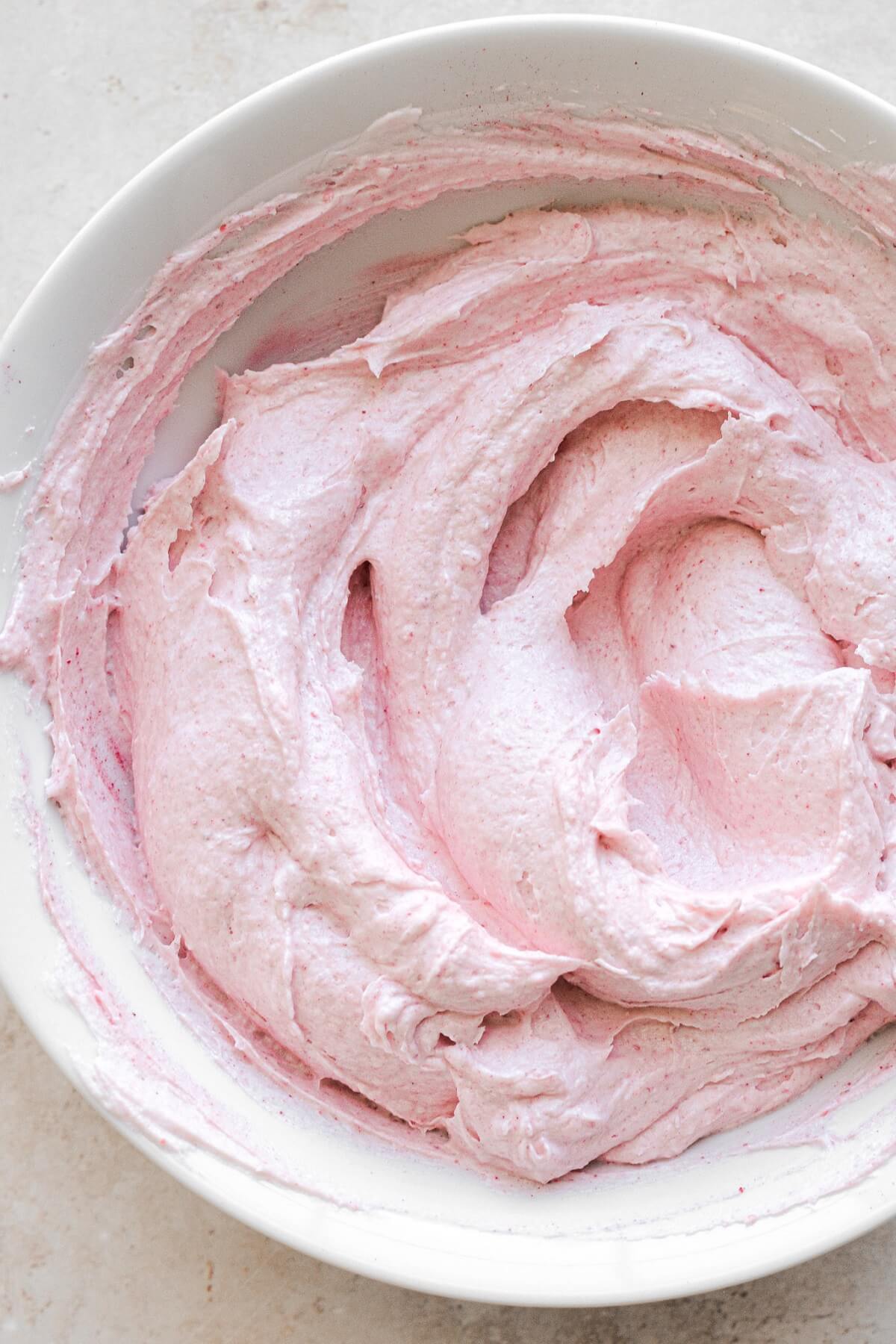 Bowl of pink raspberry buttercream.