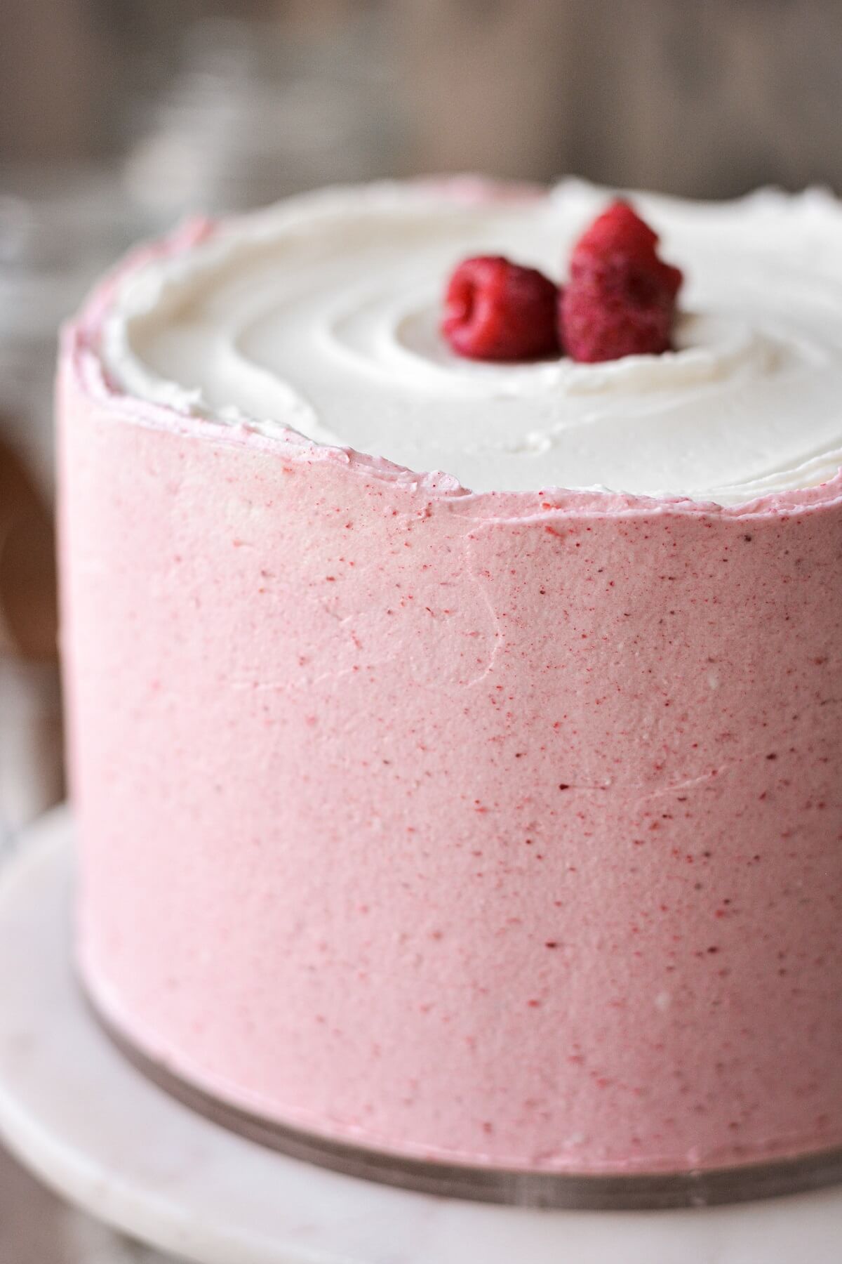 Raspberry vanilla cake topped with raspberries.