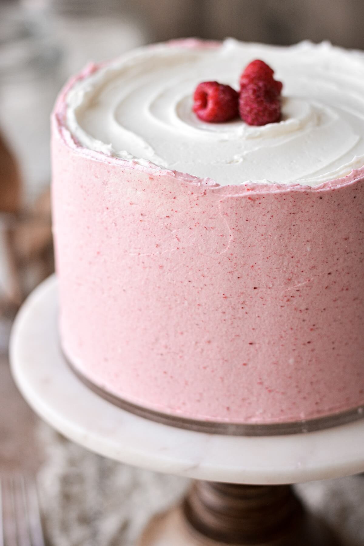 Pink and white buttercream on a raspberry vanilla cake.