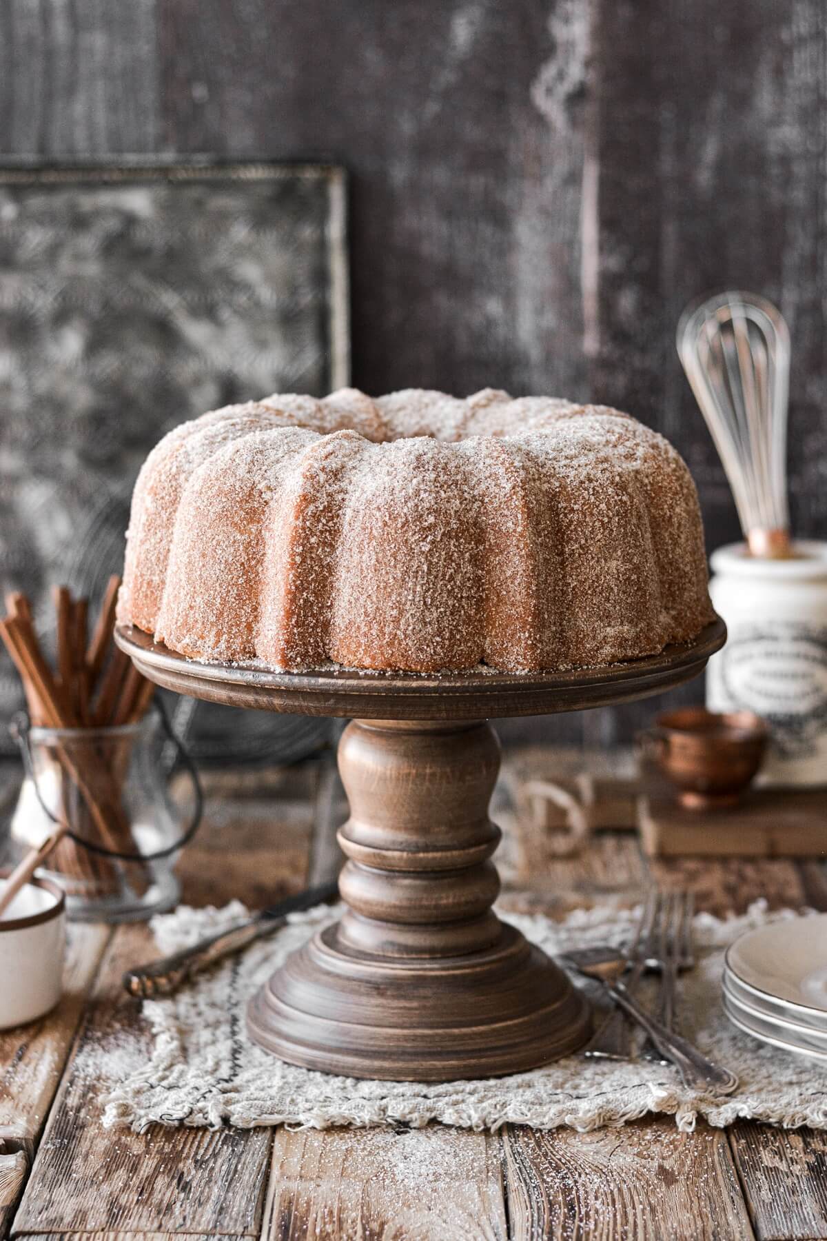 Snickerdoodle bundt cake on a wood cake stand.