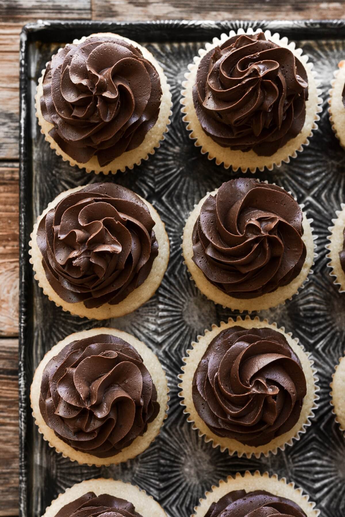 Chocolate buttercream piped onto vanilla cupcakes.