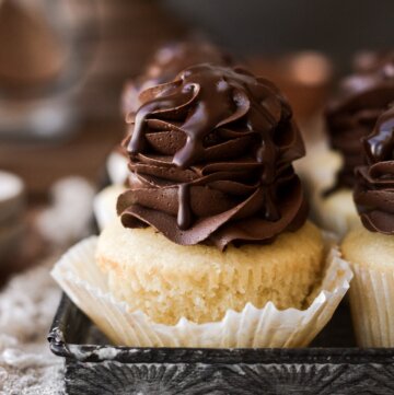Boston cream pie cupcake with the wrapper pulled back.