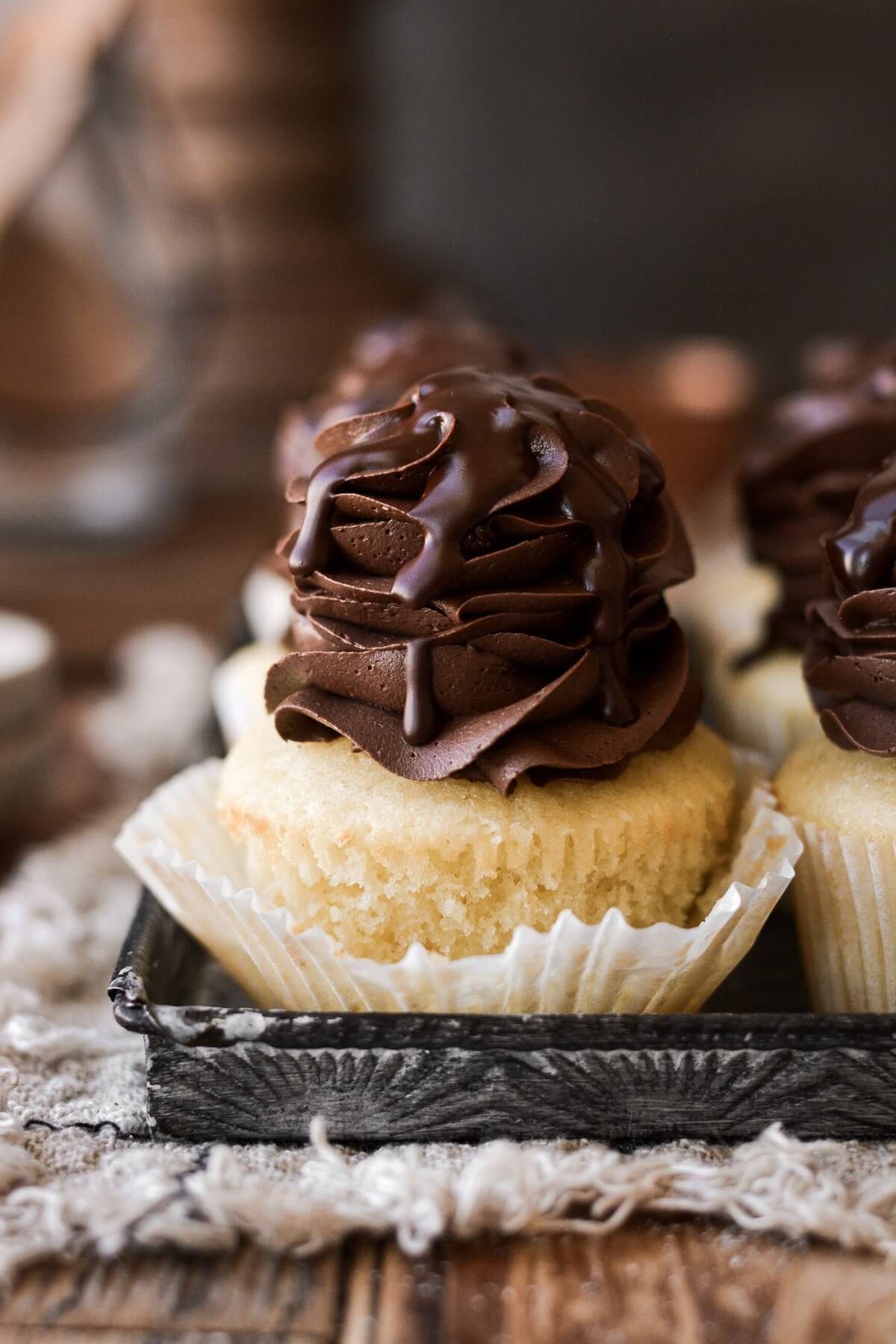 Boston cream pie cupcake with the wrapper pulled back.