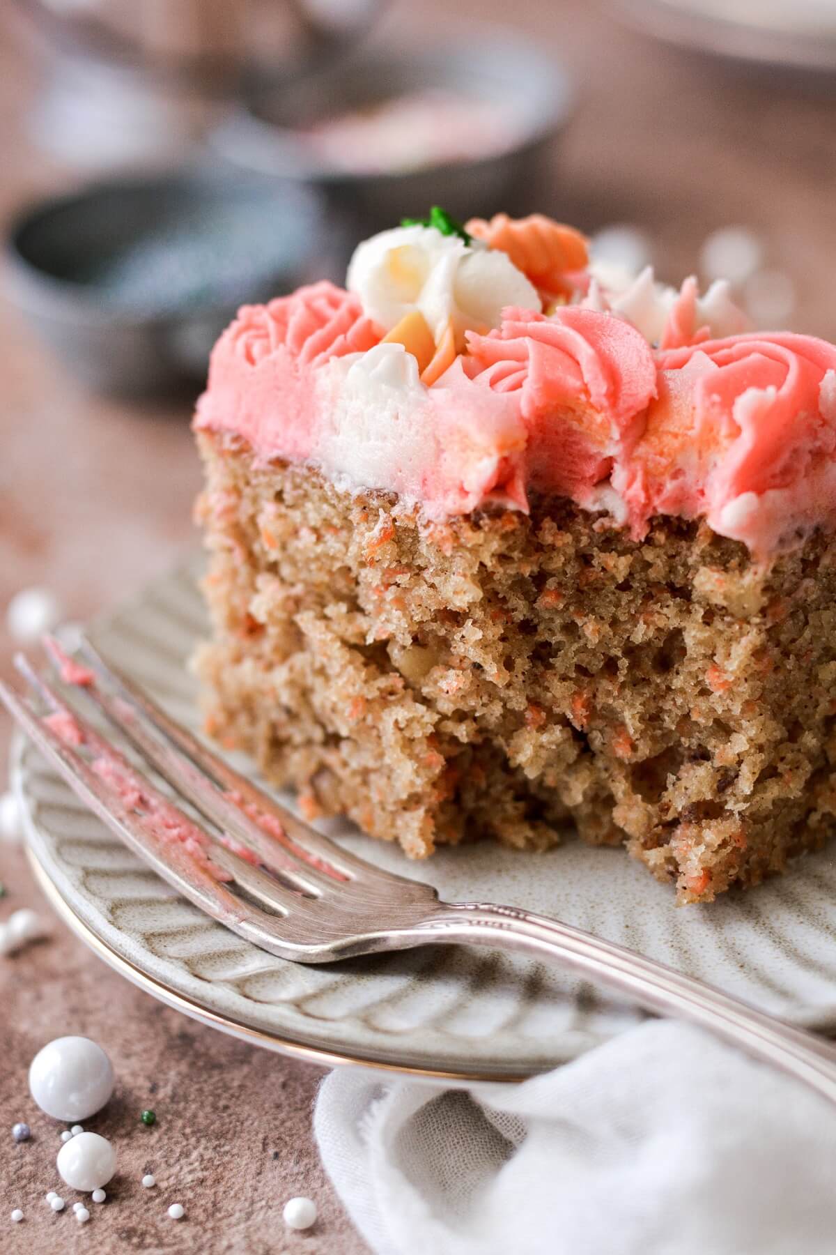 A piece of carrot cake with a bite taken.