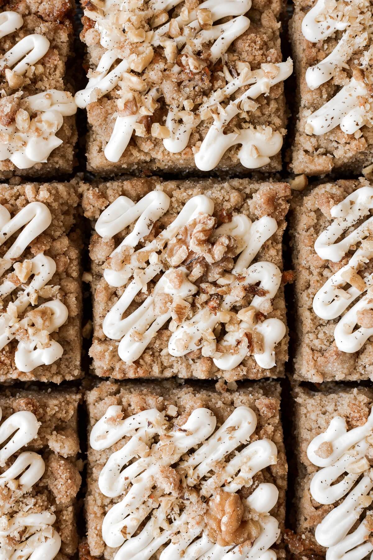 Cream cheese icing and walnuts on squares of carrot crumb cake.
