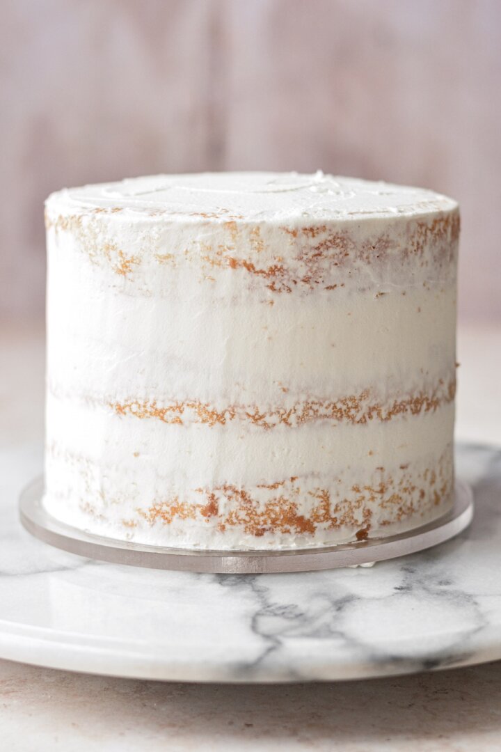 Cake with a crumb coat of buttercream.