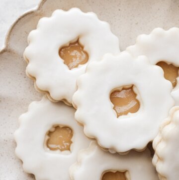 Lemon linzer cookies on a plate.