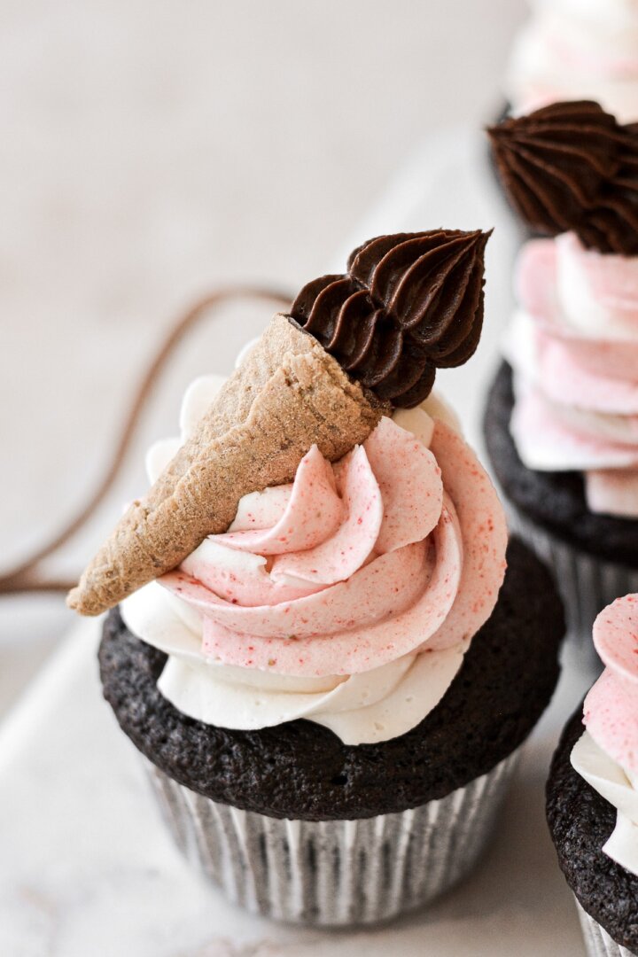 Neapolitan cupcake topped with a mini ice cream cone.