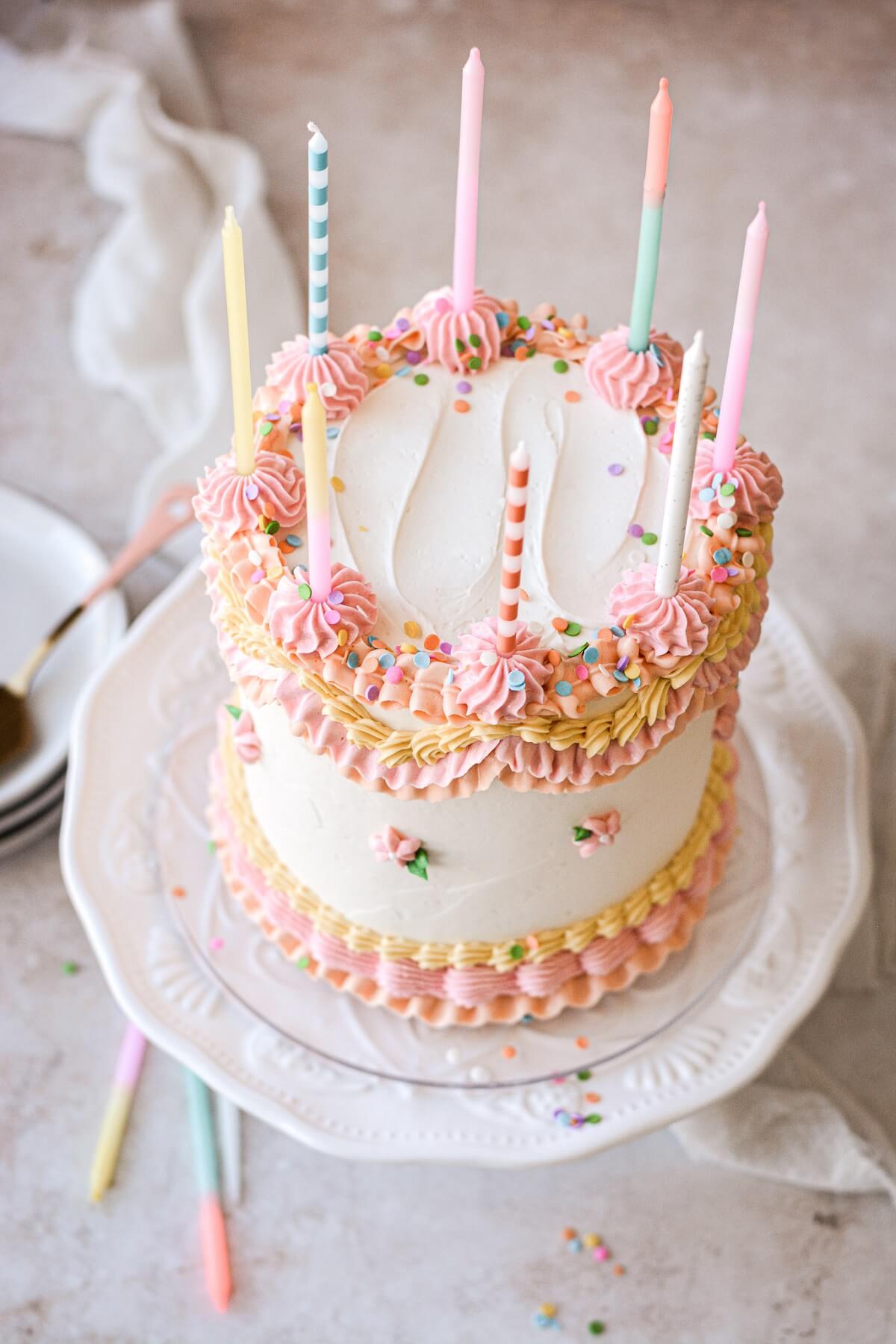 Birthday candles on a cake with vintage piping.