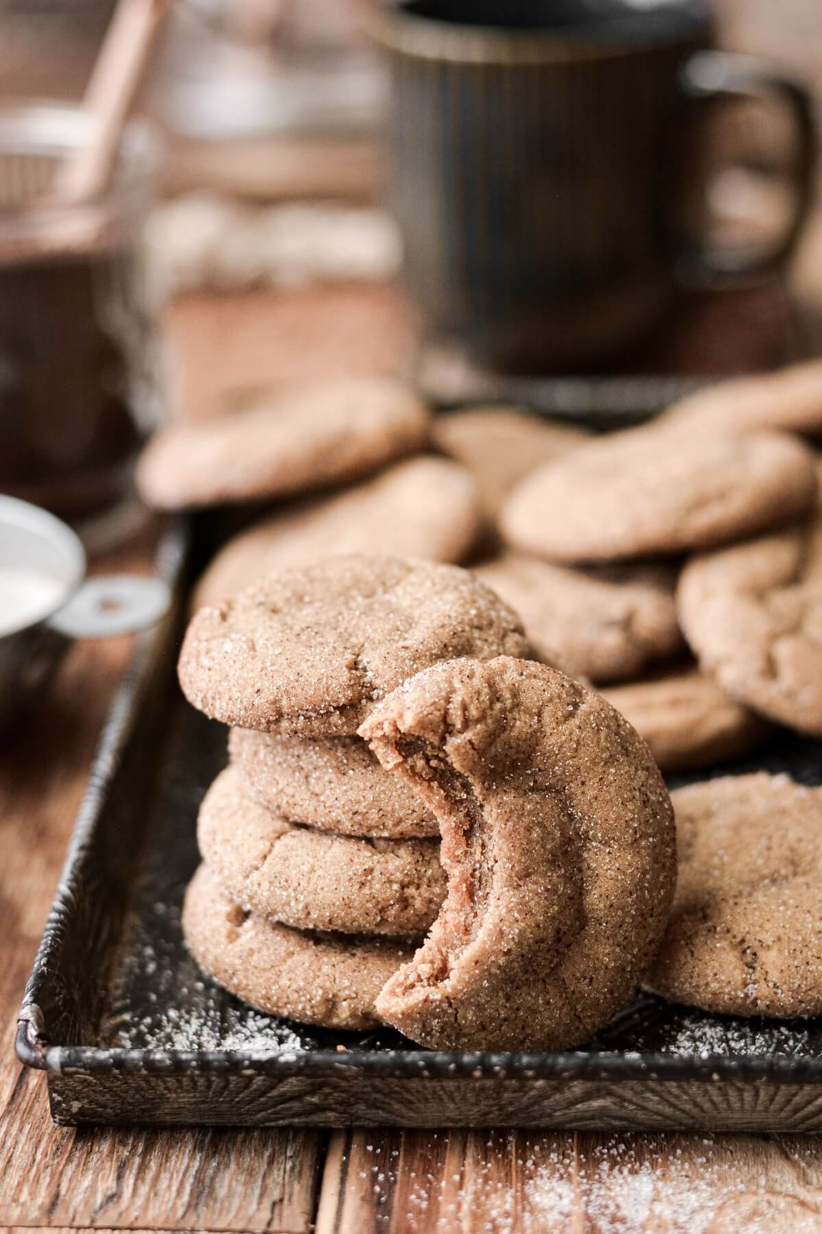 Coffee cookies, one with a bite taken, arranged on a baking sheet.