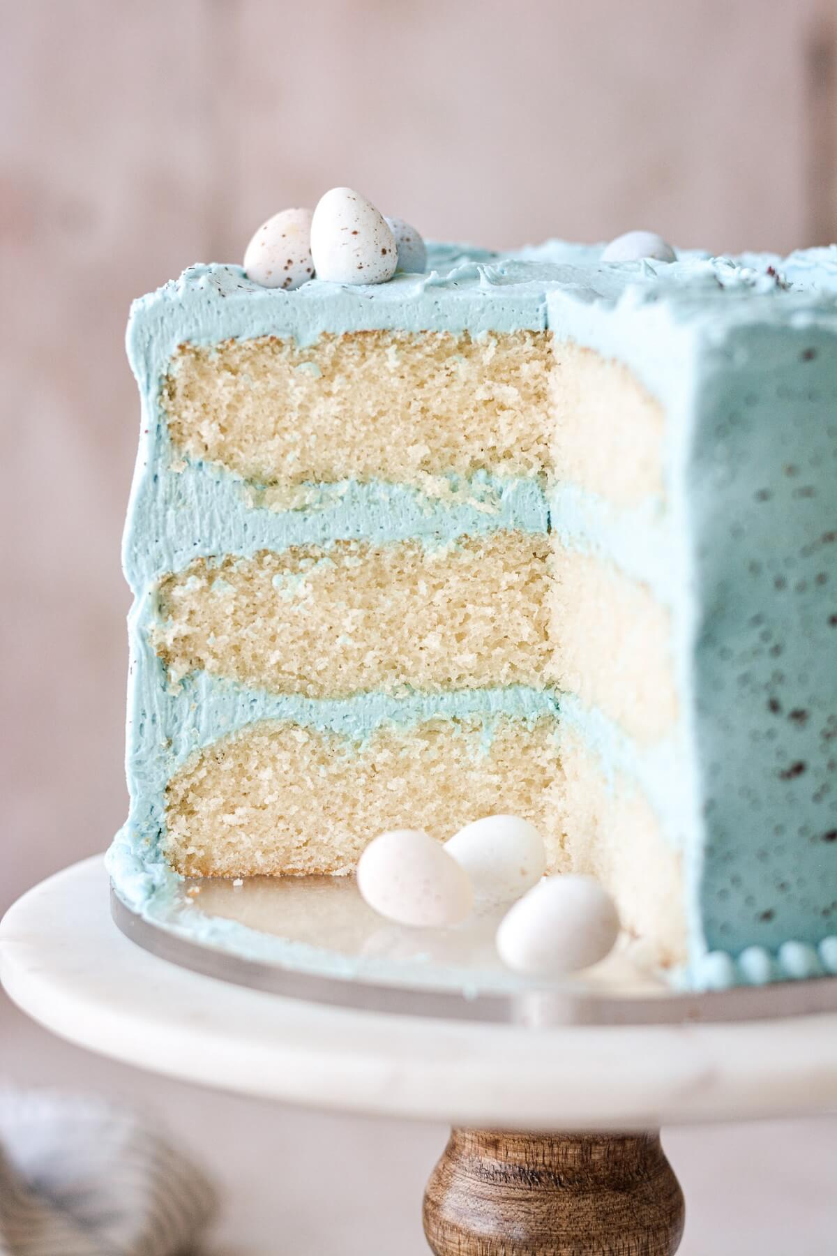 Malted milk cake with blue buttercream with a slice cut.