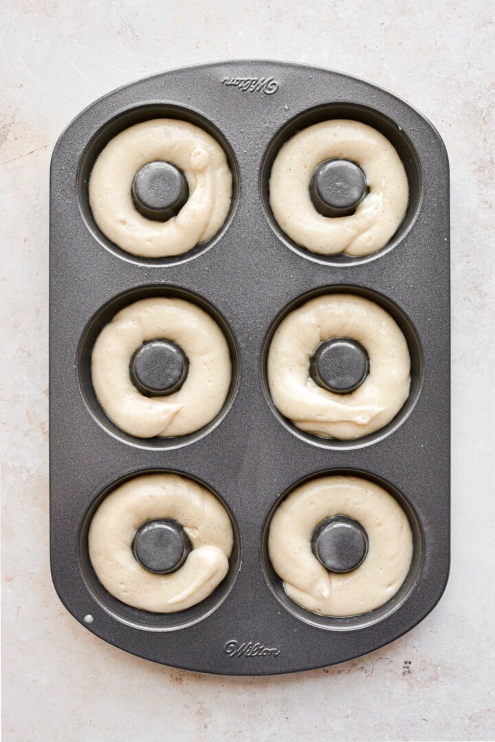 Step 5 for making baked vanilla cake donuts.