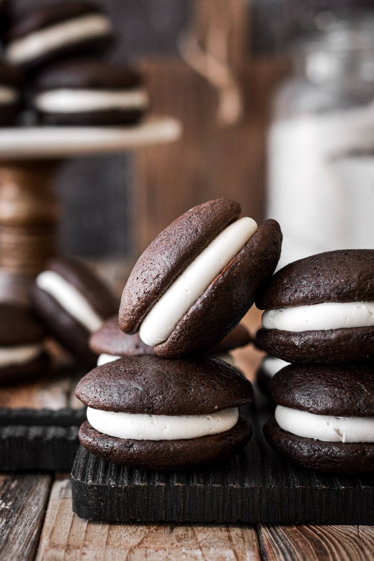 Chocolate whoopie pies with vanilla buttercream filling on a wooden board.