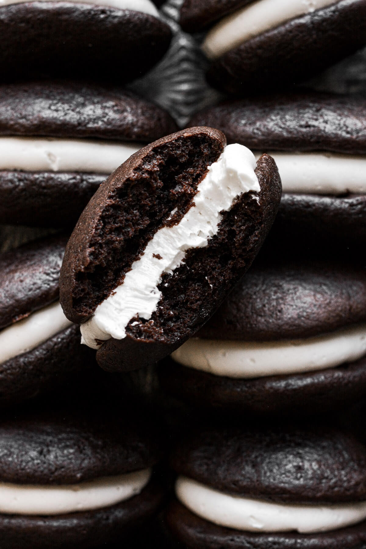 Chocolate whoopie pie with cream filling with a bite taken.