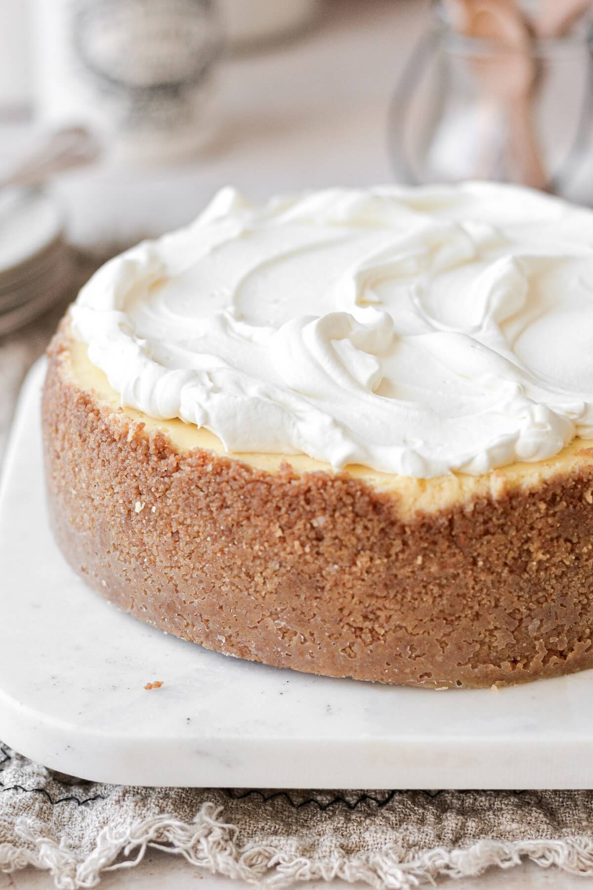 Whipped cream swirled on top of vanilla bean cheesecake.
