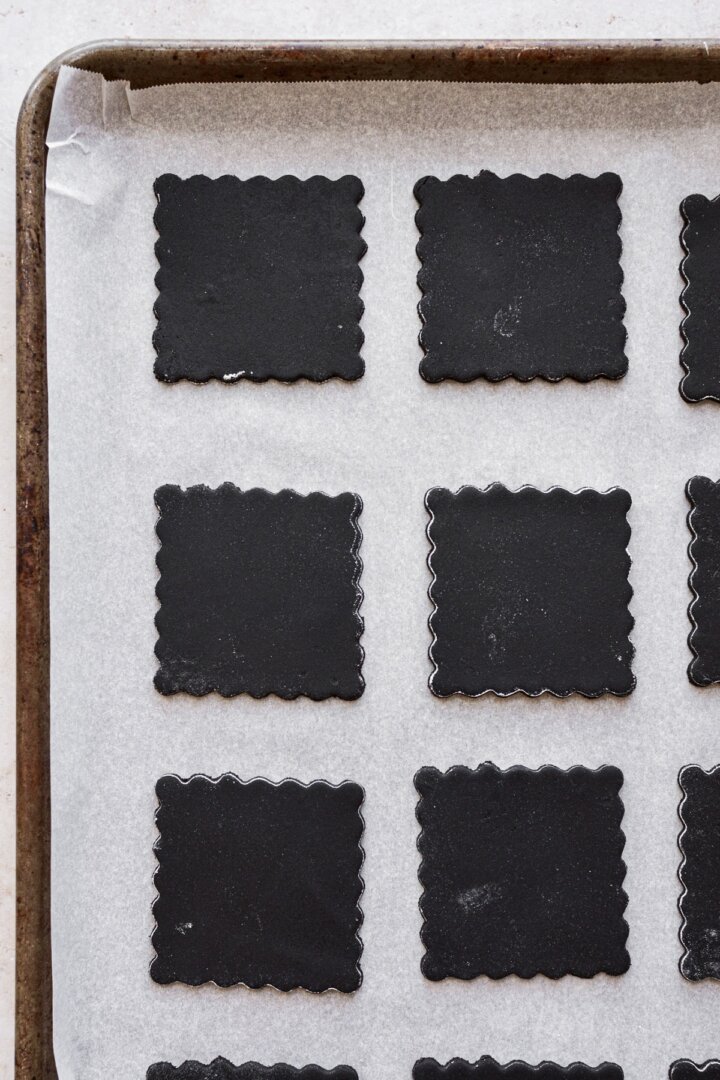 Chocolate cookie dough, cut into squares with scalloped edges.