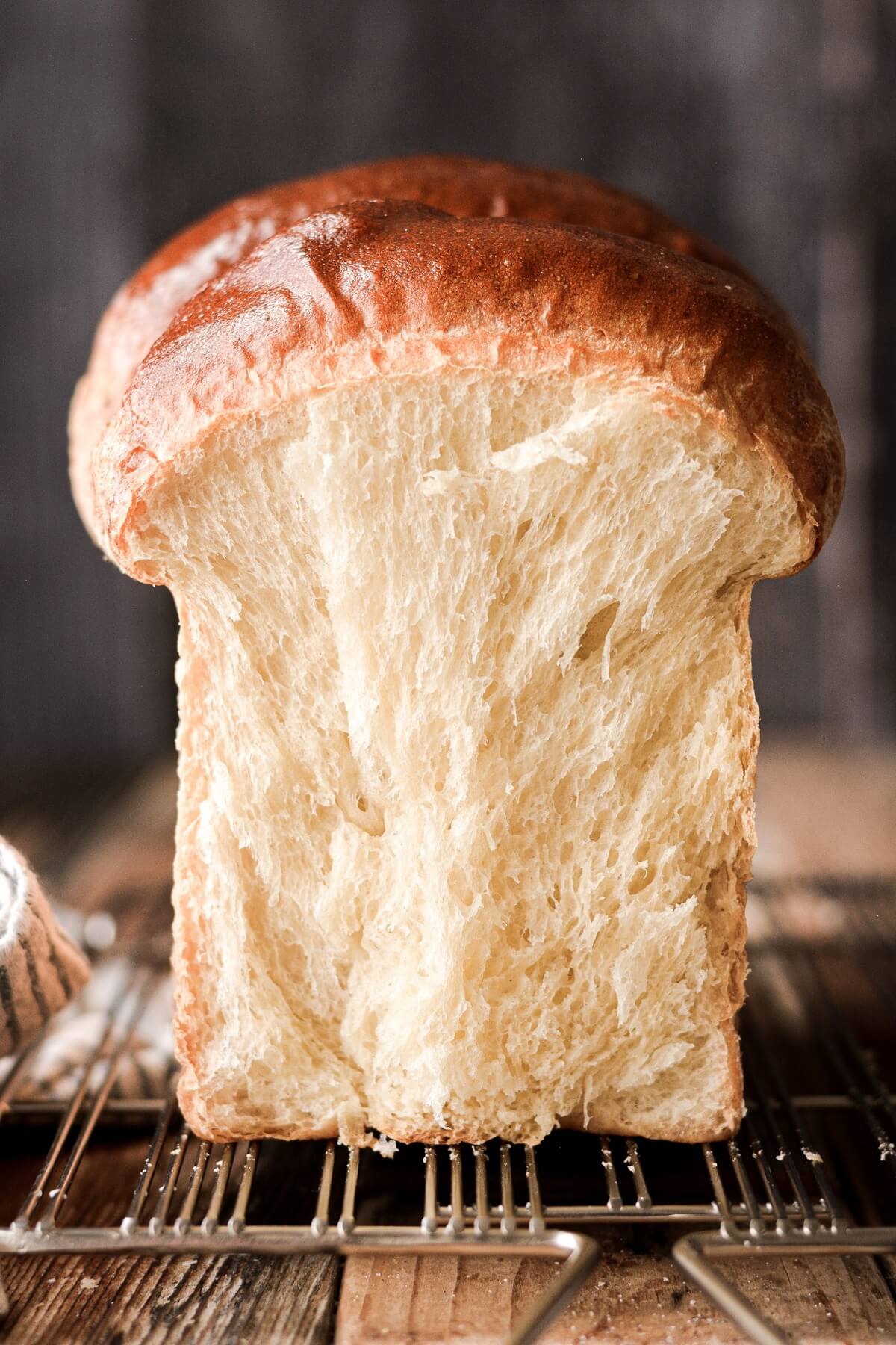 Milk bread with one slice cut to show the texture inside.