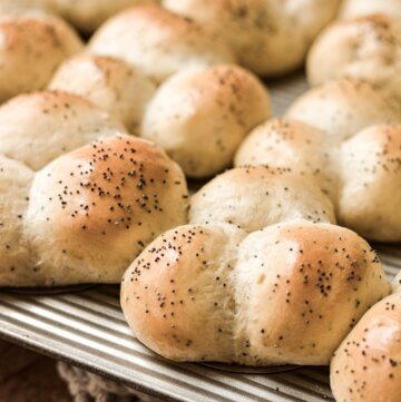 Poppy seed dinner rolls in a muffin pan.