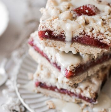 Stack of strawberry crumble bars on a plate.