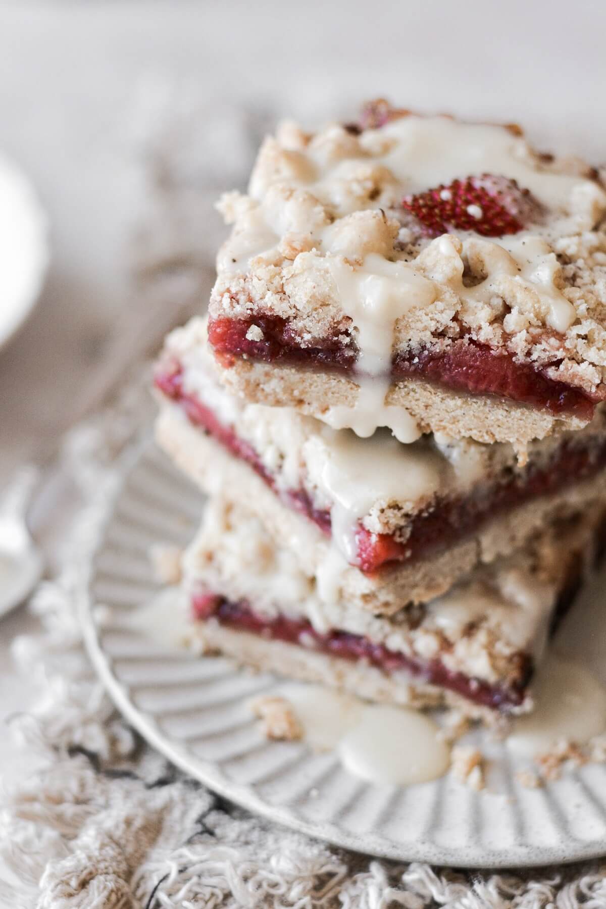 Stack of strawberry crumble bars on a plate.