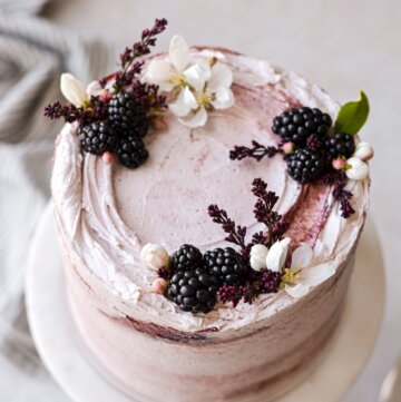 Blackberry cake decorated with blackberries and fresh flowers.