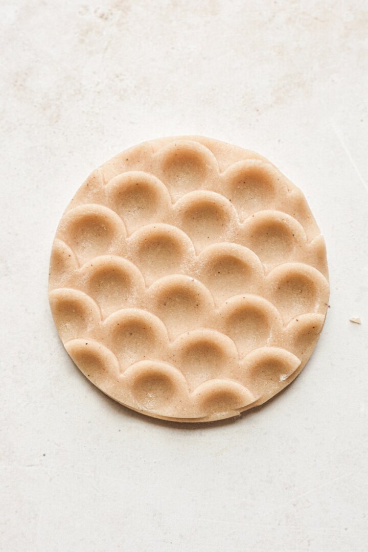 Whole wheat shortbread cookie dough pressed with a cookie stamp.