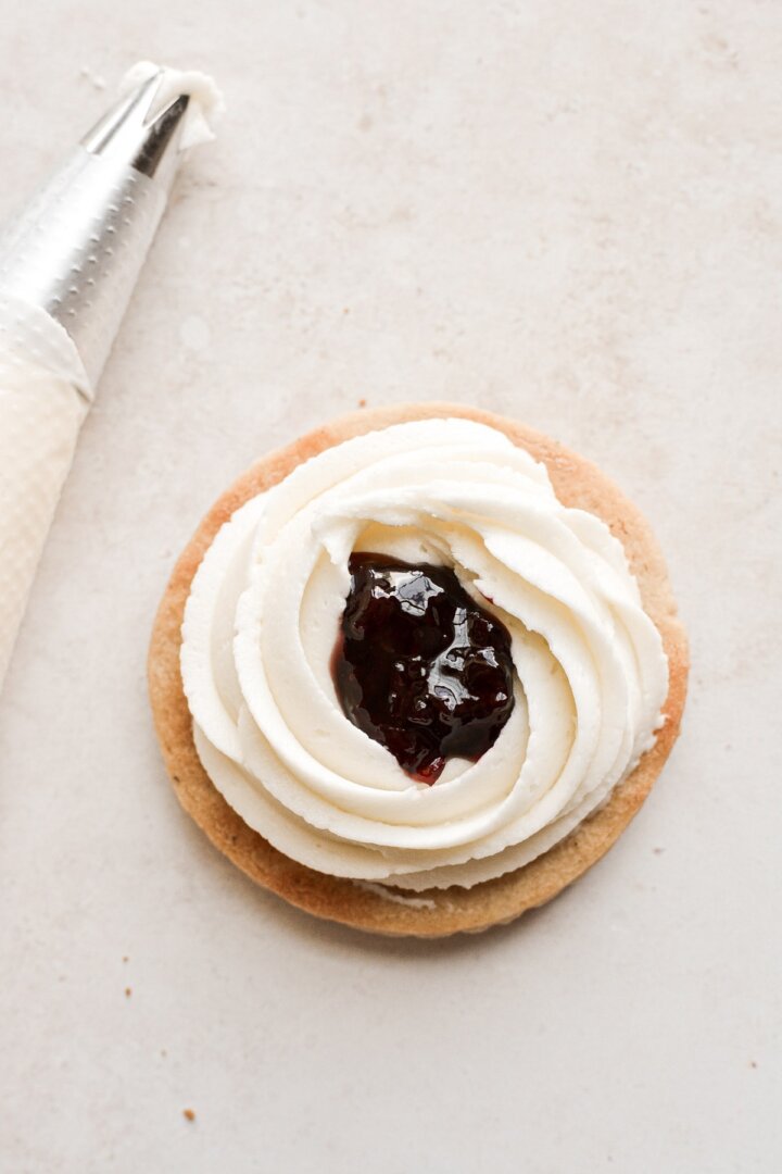 Shortbread cookie with cream cheese filling and cherry jam.