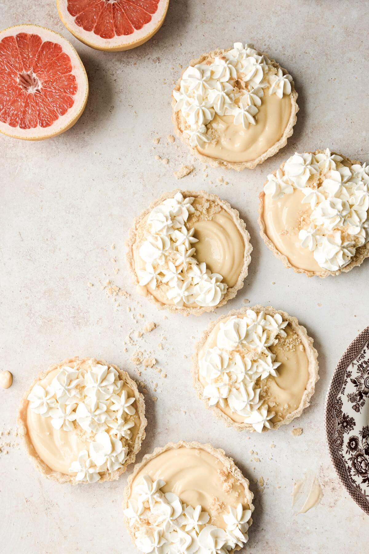 Grapefruit tarts with whipped cream cheese piped on top in drop flowers.