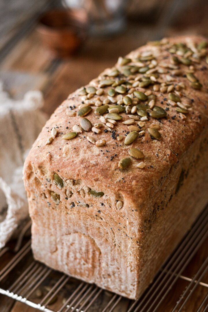 A loaf of whole wheat sandwich bread sprinkled with seeds.