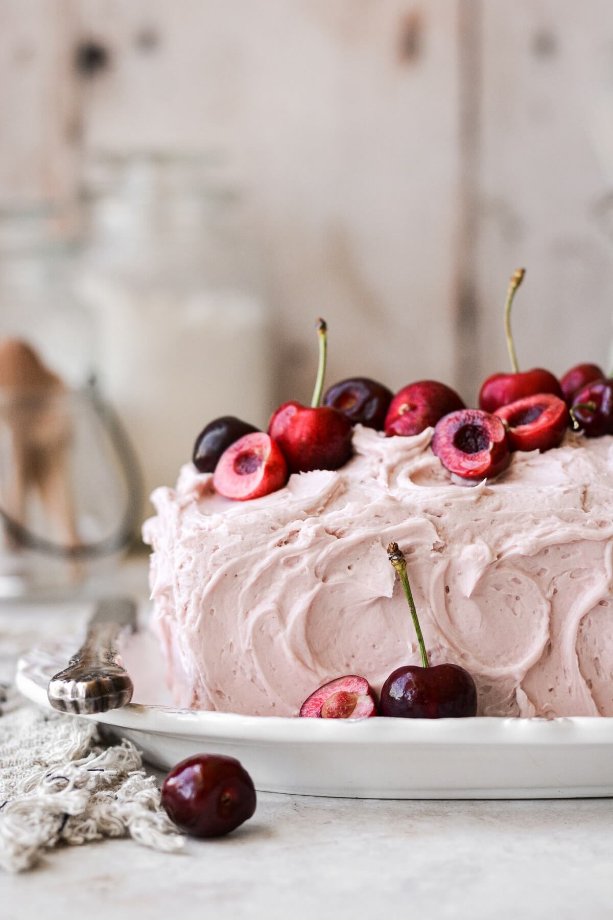 Fresh cherries on a pink frosted loaf cake.